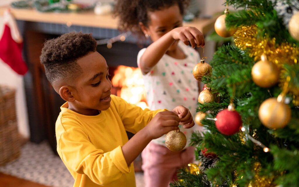 crianças decoram árvore de Natal
