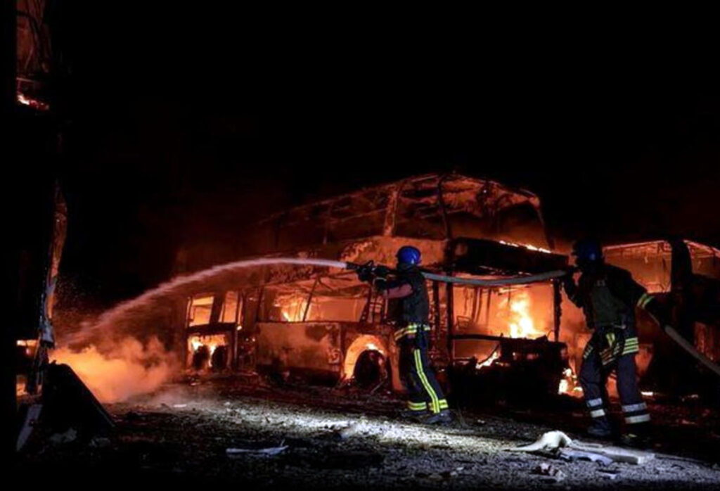 Uma imagem fornecida pelo Serviço de Emergência do Estado da Ucrânia mostra bombeiros apagando um incêndio em um estacionamento causado pelos restos de um míssil russo derrubado em Kiev, em 16 de maio de 2023.